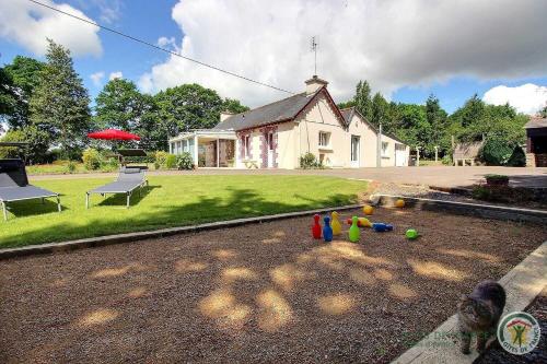 a house with a group of toys in the yard at Des trois fleurs in Plouguenast Langast