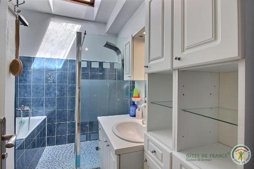 a bathroom with a sink and a glass shower at Des trois fleurs in Plouguenast Langast