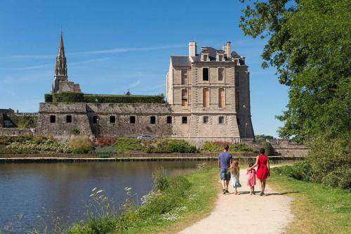 a family walking down a path in front of a castle at Des trois fleurs in Plouguenast Langast