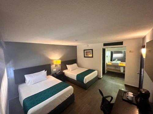 a hotel room with two beds and a bathroom at InHouse Hotel Obregón in Ciudad Obregón