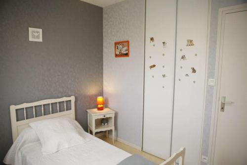 um quarto com uma cama, um armário e uma vela em Les cerisiers 
