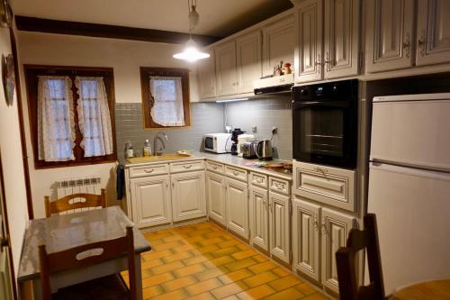 a kitchen with white cabinets and a yellow tile floor at CHARMANTE MAISON A SAINT GUILHEM LE DESERT in Saint-Guilhem-le-Désert