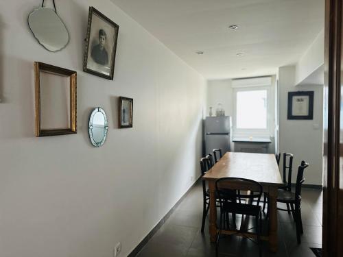 a kitchen and dining room with a table and chairs at Maison Pi Mouss' à 150m de la mer in Cayeux-sur-Mer
