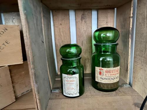 two green bottles are sitting in a box at Maison Pi Mouss' à 150m de la mer in Cayeux-sur-Mer