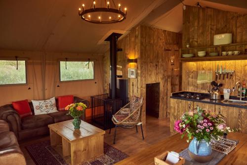 a living room with a couch and a table at Tall Trees Glamping in Baltonsborough