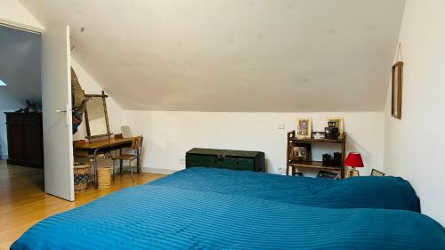 a bedroom with a blue bed and a desk at Maison Pi Mouss' à 150m de la mer in Cayeux-sur-Mer