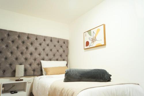 a bedroom with two beds and a tufted headboard at Apto a 2 minutos de Parque la Valvanera in Bogotá