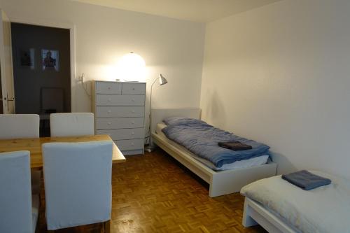 Schlafzimmer mit einem Bett, einem Tisch und Stühlen in der Unterkunft Basel Rooms Appartements in Basel