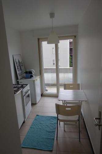 a kitchen with a table and chairs and a window at Basel Rooms Appartements in Basel