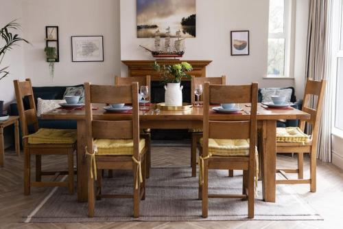 a dining room with a wooden table and chairs at Luxury Waterfront House in Cobh