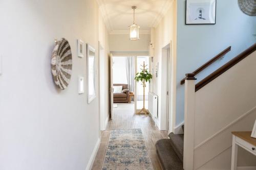 a hallway with white walls and a stairway with a rug at Luxury Waterfront House in Cobh