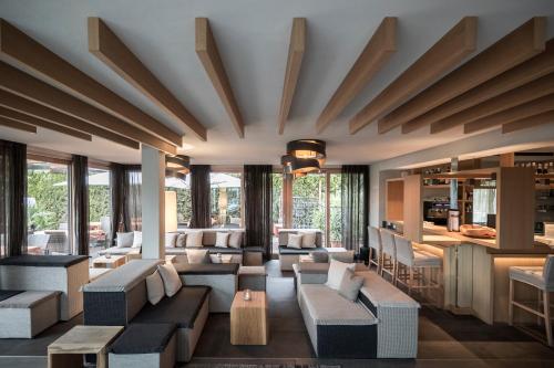 a living room with couches and tables and windows at Das Panorama Dependance in Caldaro
