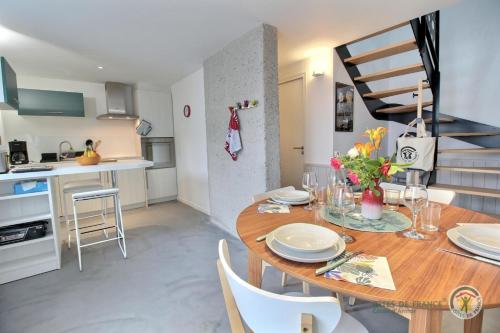 une cuisine et une salle à manger avec une table et des chaises en bois dans l'établissement La ritournelle, à Pleslin-Trigavou