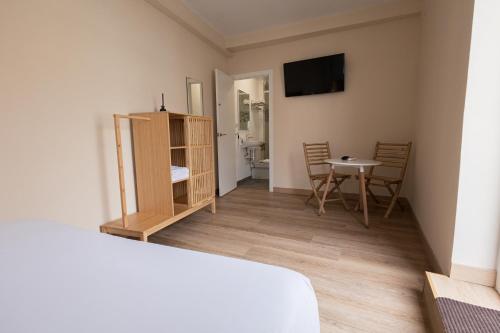 Habitación con cama y mesa con sillas. en The Clover, en Sevilla