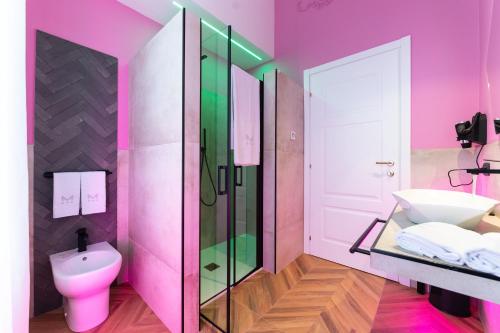a pink bathroom with a sink and a toilet at Momento Soggiorno di Charme in Foggia
