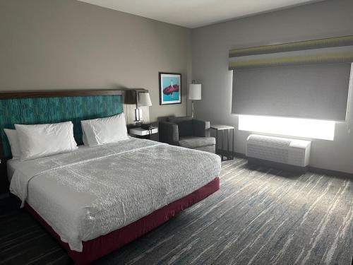 a hotel room with a bed and a chair at Hampton Inn & Suites Ruskin I-75, FL in Ruskin