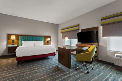 um quarto de hotel com uma cama e uma secretária com um computador em Hampton Inn & Suites Ruskin I-75, FL em Ruskin