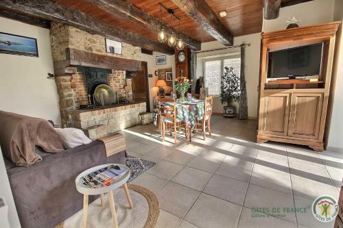 un salon avec un canapé et une cheminée dans l'établissement La maison d'anais, à Pleudihen-sur-Rance