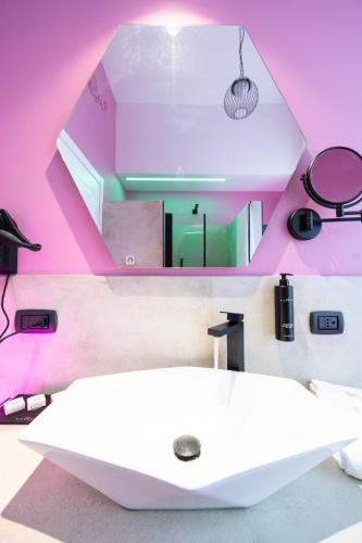 a bathroom with a white sink and pink walls at Momento Soggiorno di Charme in Foggia