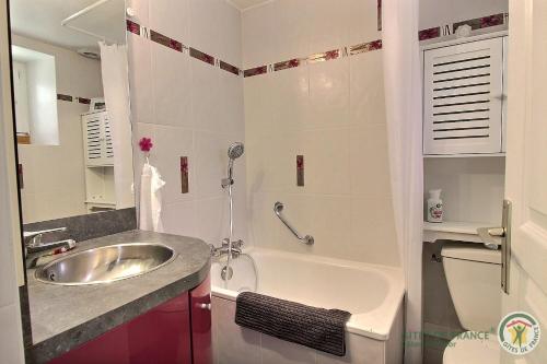 une salle de bain avec un lavabo et une baignoire dans l'établissement La maison d'anais, à Pleudihen-sur-Rance