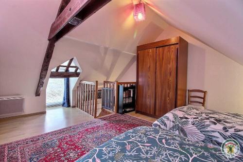 - une chambre mansardée avec un lit et une armoire en bois dans l'établissement La maison d'anais, à Pleudihen-sur-Rance