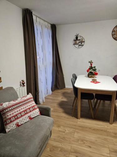 ein Wohnzimmer mit einem Tisch und einem Sofa in der Unterkunft Studio Le Tétras Résidence de tourisme in La Feclaz