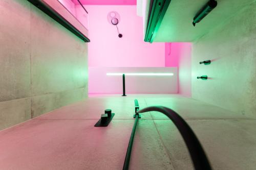 a room with pink and green lighting and a bench at Momento Soggiorno di Charme in Foggia
