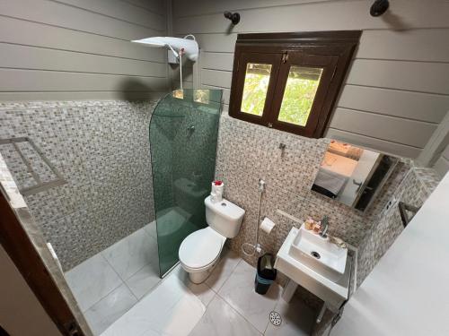 a bathroom with a shower and a toilet and a sink at Pousada Piraúna in Fernando de Noronha