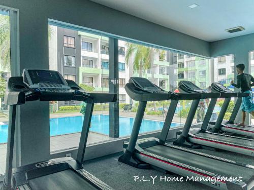 a gym with three treadmills and a swimming pool at PoolView Waterpark 300Mbps Ipoh Homestay Manhattan Condo 4-7pax 3bedroom Station 18 pengkalan in Ipoh