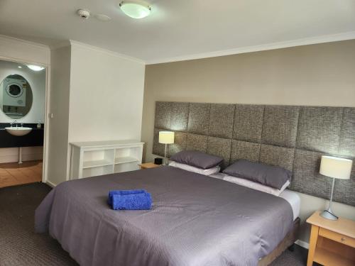 a bedroom with a large bed with a blue box on it at Canberra City Accommodation in Canberra
