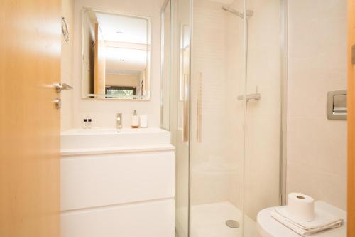 uma casa de banho com um chuveiro, um WC e um lavatório. em Scala Cascais Top apartment em Cascais