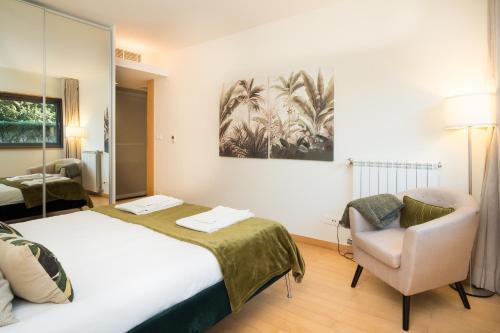 a hotel room with a bed and a chair at Scala Cascais Top apartment in Cascais
