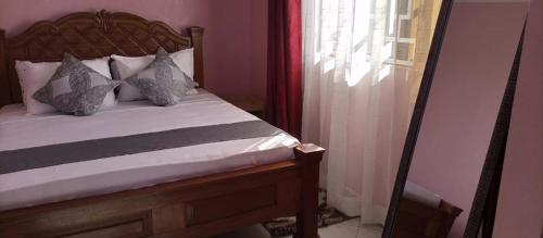 een slaapkamer met een bed en een raam bij 93 Annex in Mombasa