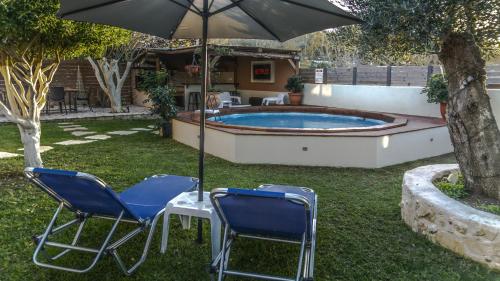 two chairs and an umbrella next to a pool at Star Jasmine House Acharavi in Litherés