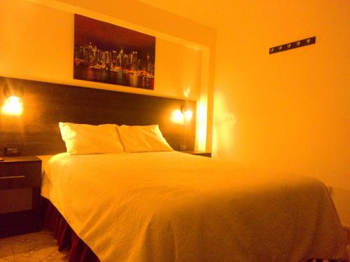 a bedroom with a white bed and a picture on the wall at ANDAHUAYLAS CENTRO in Andahuaylas