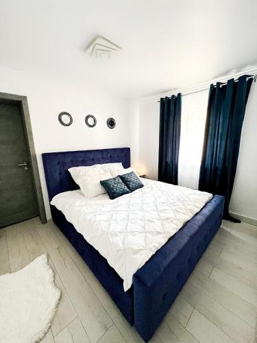 a bedroom with a blue bed with blue curtains at Luxor - Jacuzzi&Cozy Apartments in Sibiu