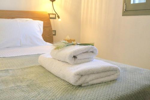 a pile of towels sitting on top of a bed at Unity Villa in Pilaroú