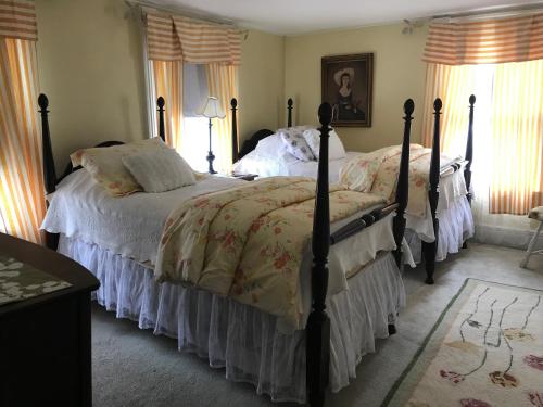 a bedroom with two beds with white comforters at The Monadnock Inn in Jaffrey