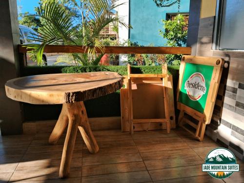 einem Holztisch und einer Bank neben einem Schild in der Unterkunft Jade Mountain Suites, Jarabacoa in Jarabacoa