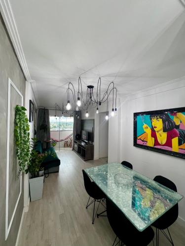 a living room with a table and a dining room at Apartamento decorado no Jardim Lancaster in Foz do Iguaçu