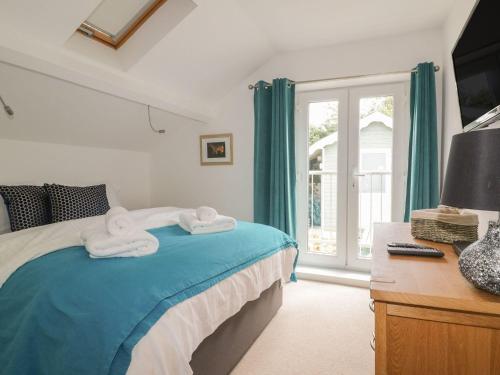 a bedroom with a bed with towels on it at Blacksmiths Cottage in Newquay