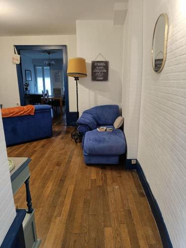 a living room with a blue couch and a chair at Appartement au charme authentique in Mirecourt