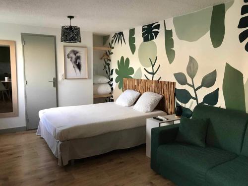 - une chambre avec un lit et un canapé vert dans l'établissement Cit'hotel Design Booking Evry Saint-Germain-lès-Corbeil Sénart, à Saint-Germain-lès-Corbeil