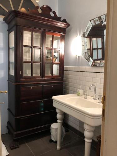 a bathroom with a sink and a wooden cabinet at Studio Rempart in Brussels