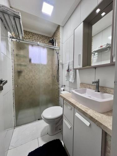 a bathroom with a shower and a toilet and a sink at Apartamento decorado no Jardim Lancaster in Foz do Iguaçu