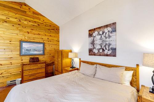 1 dormitorio con 1 cama y pared de madera en Inn at Silver Creek #630, en Granby
