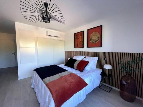 une chambre avec un grand lit et un lustre dans l'établissement Studio 108 2 personnes Tennis, au Cap d'Agde