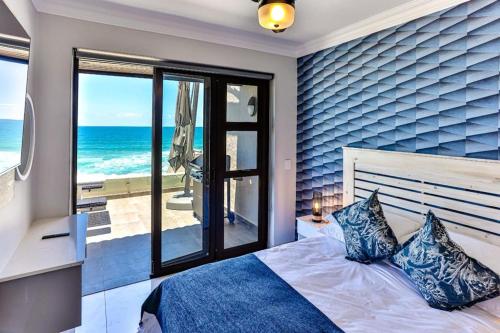 a bedroom with a bed with a view of the ocean at Chakas Terrace 7 - Luxurious Beach House in Ballito