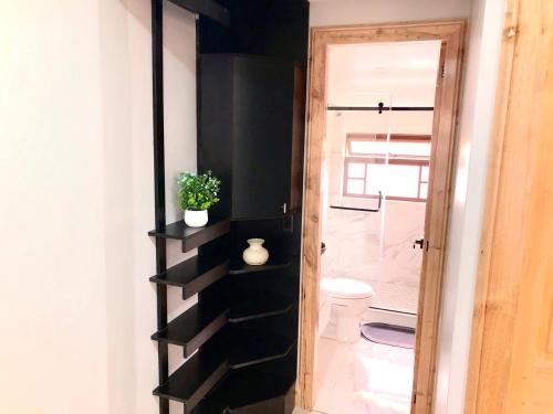 uma casa de banho com uma prateleira preta ao lado de um WC em Family Apartment centro ciudad + Netflix em Cuenca