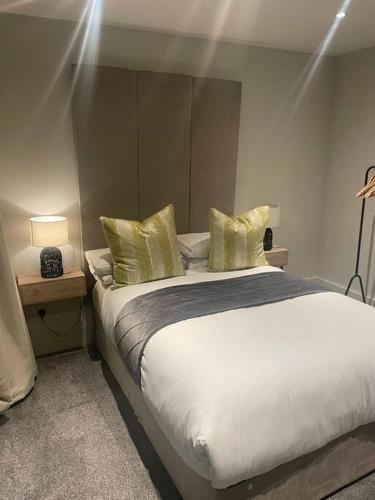 a bedroom with a large bed with yellow pillows at Luxurious 1 Bed - CITY VIEWS in Liverpool